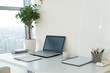 © undrey - Side view picture of studio workplace with blank notebook, laptop. Designer comfortable work table, home office.
