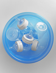 Fototapete - Baby bottles in plastic blue basin