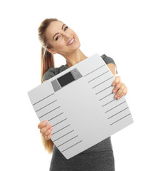 Wall Mural - Beautiful young woman holding floor scales on white background