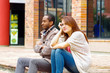 © Fotos 593 - Interracial upset couple sitting on steps in front of building, simulating argument for camera