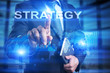 © WrightStudio - Businessman is pressing on the virtual screen and selecting Strategy.