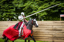 Armored Knight On Horseback Charging In A Joust With The Lance Raised. Jousting Is A Martial Game Or Hastilude Between Two Horsemen Wielding Lances With Blunted Tips, Often As Part Of A Tournament