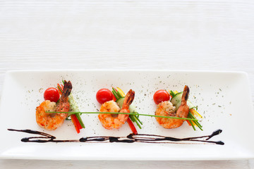 Horizontally lying three grilled shrimps on white, void. Mediterranean cuisine menu