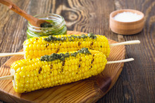 Grilled Corn On Cob With Pesto Sauce On Wooden Board