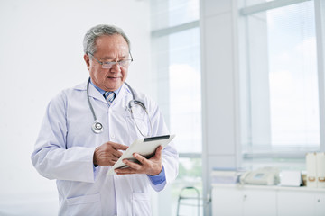 Portrait of Asian doctor using tablet computer