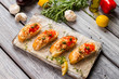 Sliced baguette with fish meat. Garlic and green herb. Freshly cooked meal on table. Recipe of salmon bruschetta.