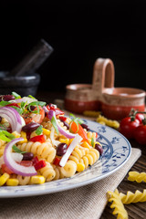 Mexican pasta salad with red bean, corn, tomato, onion and pepper