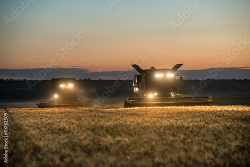 Carta da parati  Combine harvester working on a wheat crop at night
