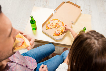 Sticker - Top view of young happy family watching tv with beer and pizza