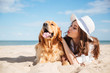 Woman having fun and kissing her dog on the beach