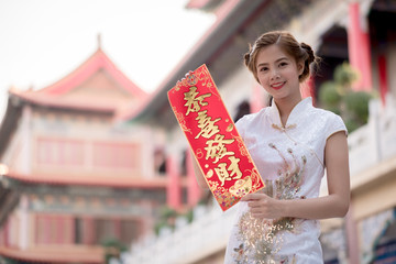 The Asian woman in chinese dress holding couplet 'Lucrative.' (C