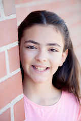 Wall Mural - Preteenager girl next to a red brick wall