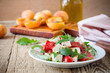 Feta arugula salad with tomatoes on white plate, summer food
