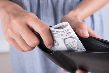 hands show money dollar bills in black wallet. business finance