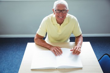 Wall Mural - senior man using braille to read