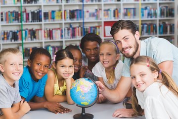 Poster - Pupils and teacher looking at globe in library 