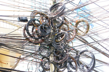 choas, messy, tangle of electric cable post in thailand