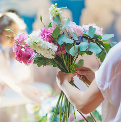 Hands of florist woman creating bouquets for wedding decoration