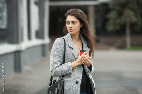 Fotografie, Tablou Lifestyle fashion portrait of beautiful young brunette woman in grey coat with c