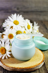 Jar with cosmetic cream on a wooden surface.