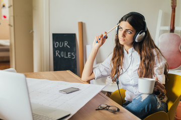 College student studying and listening the music in her home