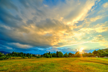 Wall Mural - beautiful background landscape at sunset time, with colorful clouds on sky illuminated by sun, in su