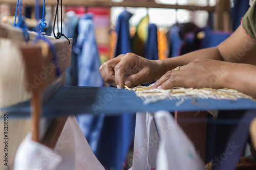 Fotografie, Obraz Girl weaving traditional sarong from northern Thailand