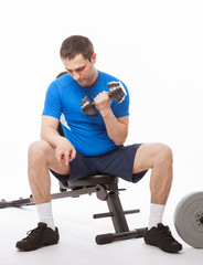 Young man doing exercises with dumbbells