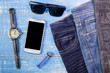 © bubbers - Smart phone, sunglasses,  jeans and watch on blue wooden  backgr