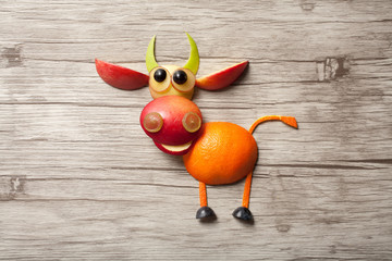 Bull made of apple on wooden background