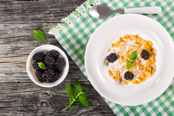 Sticker - tasty corn flakes with milk and blackberry, top view