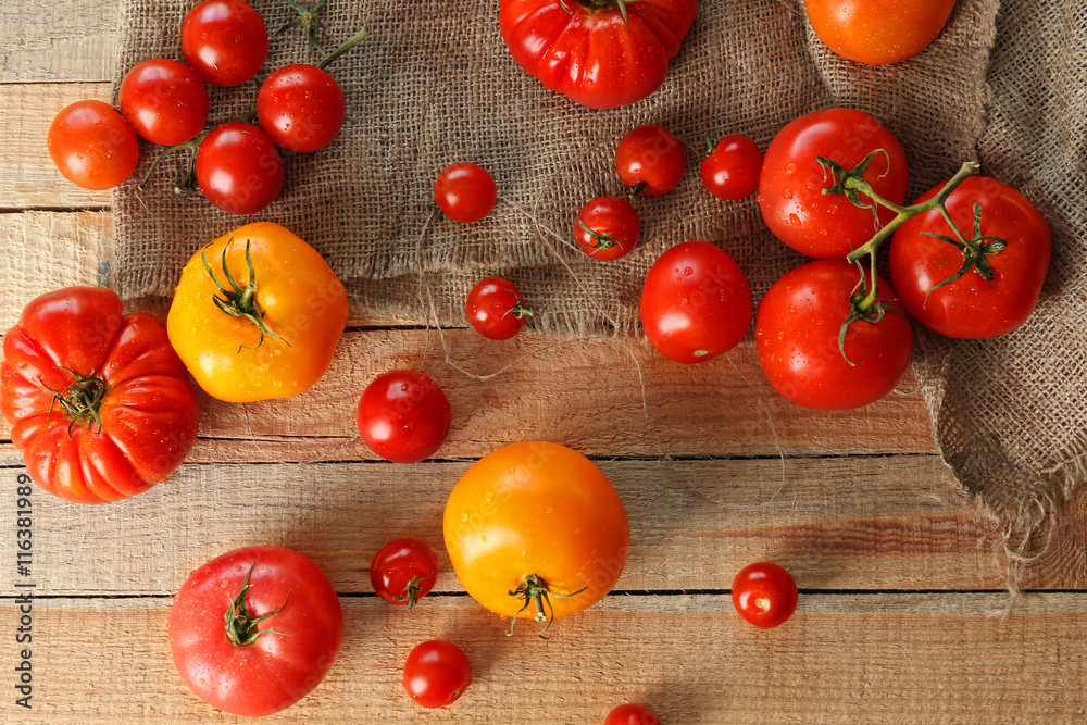 Rustic composition of tomatoes and sackcloth on wooden background