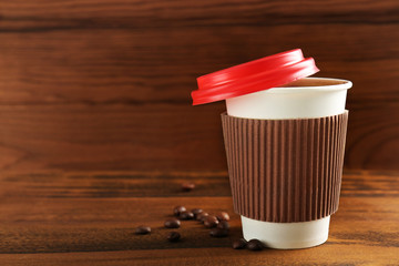 Poster - Paper cup of coffee on wooden background