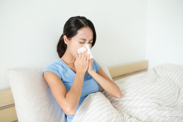 Wall Mural - Asian woman sneezing on bed