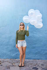 Trendy young female holding balloons