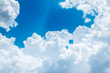 Wall Mural - looking up at big white cloud and light ray behind cloud with bl