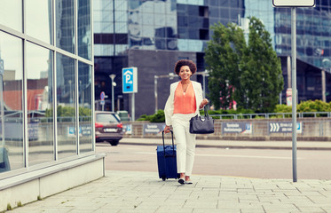 Poster - happy young african woman with travel bag in city