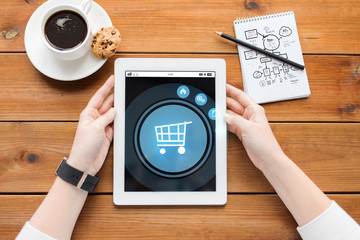 Poster - close up of woman with tablet pc on wooden table