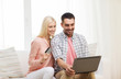 © Syda Productions - happy couple with laptop and credit card at home
