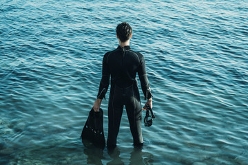 Wall Mural - Male diver standing in the sea