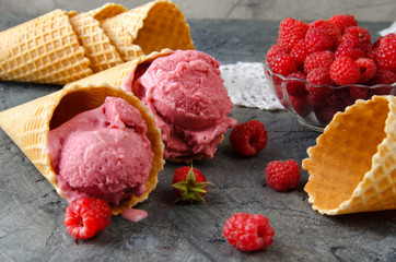 Poster - Raspberry ice cream with ice cream cones on stone table.