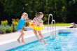 © famveldman - Kids jumping into swimming pool