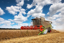 Combine Harvester Working On A Wheat Field.