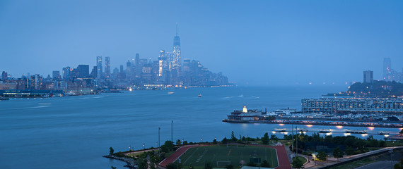 Wall Mural - Lower Manhattan with heavy rainfall in evening and Financial District skyscrapers and Weehawken, New Jersey waterfront. New York