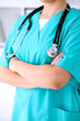 © rogerphoto - Female surgeon doctor is standing with arms crossed at hospital.  Physician  is ready to examine patient