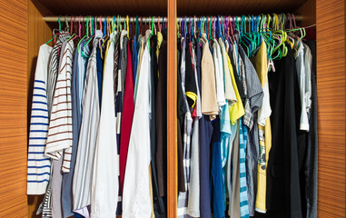 Colorful clothes men hanging in wooden closet