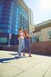 © ArtFamily - Two young beautiful females walking along the street and chattin