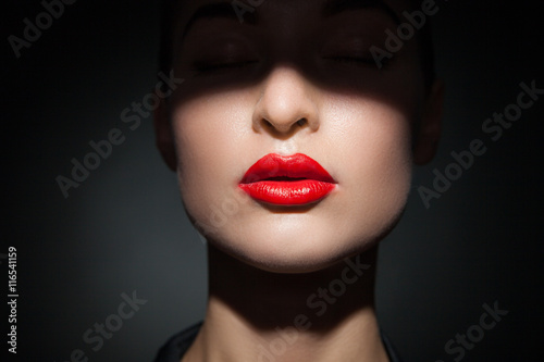 Fotomural Bella modelo con los labios rojos brillantes y el rostro medio cubierto de sombr