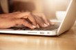 © WHstudio Leushin N - Cropped portrait of young female student learning on-line using generic laptop computer. Dark-skinned business woman sitting in front of open net-book, typing a message. Selective focus on fingers