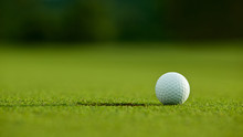 Selective Focus. White Golf Ball Near Hole On Green Grass Good F
